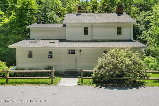 view of front of property featuring fence, roof with shingles, and entry steps