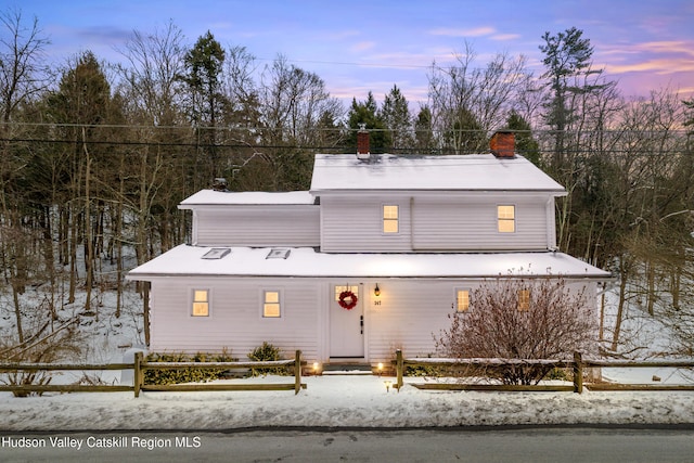 view of front of house with a chimney and fence