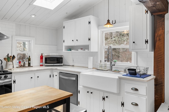 kitchen with white cabinetry, stainless steel appliances, and decorative light fixtures