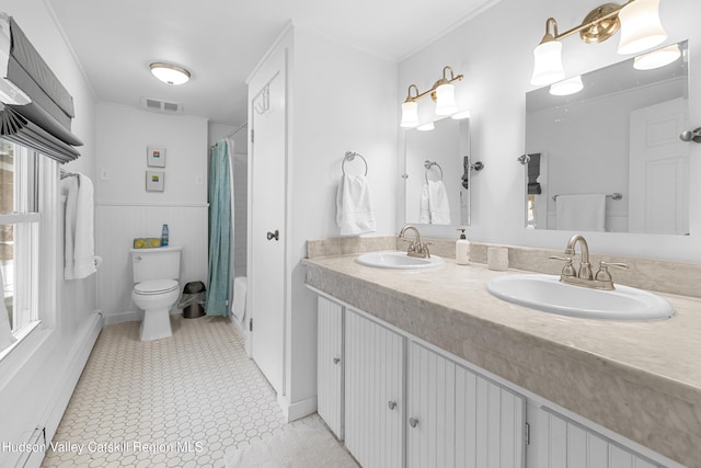 full bathroom featuring toilet, visible vents, a baseboard heating unit, and a sink