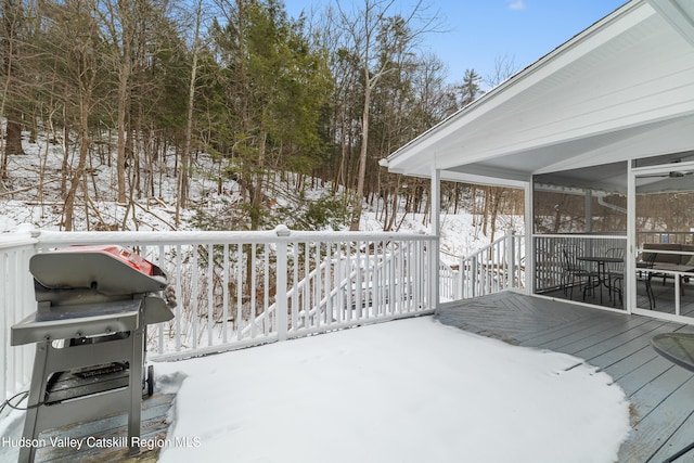 snow covered deck with a sunroom and grilling area