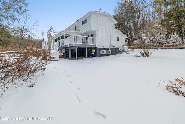 snow covered property with stairs and a wooden deck