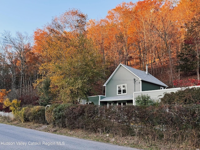 view of property exterior featuring roof with shingles