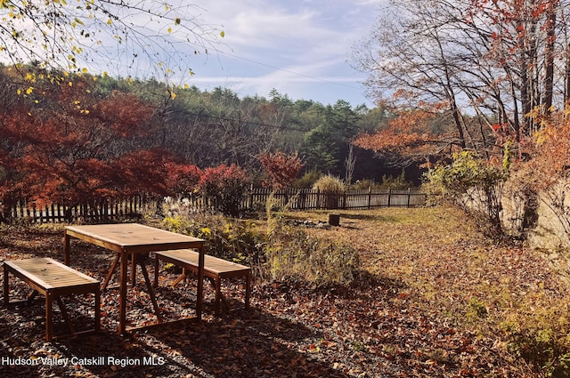 view of home's community featuring fence and a forest view