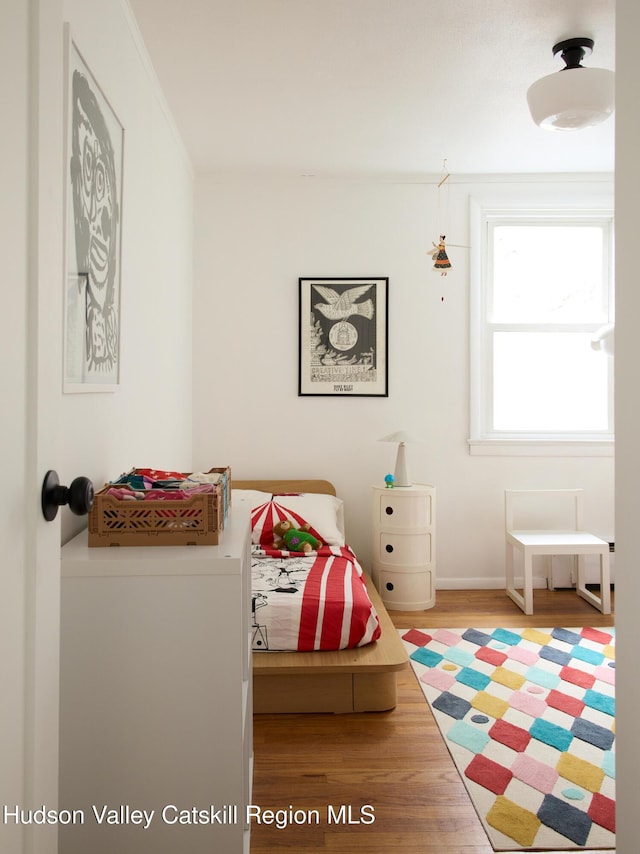 bedroom with baseboards and wood finished floors
