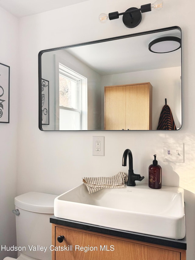 half bathroom featuring toilet and vanity