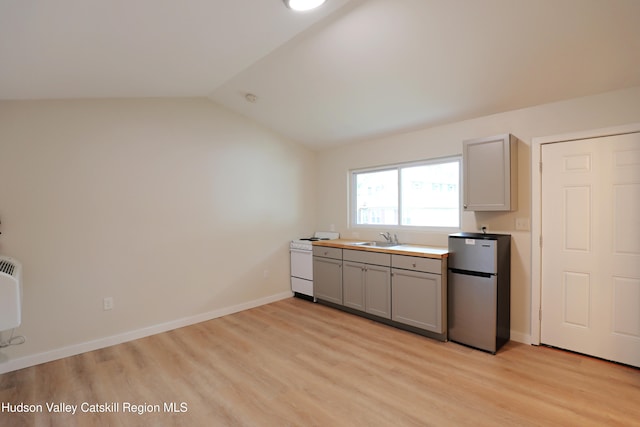 kitchen with a sink, light wood-type flooring, freestanding refrigerator, gray cabinetry, and white range with electric cooktop
