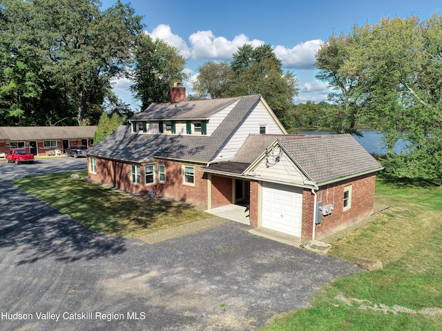 view of front of house featuring a garage, driveway, a chimney, and brick siding
