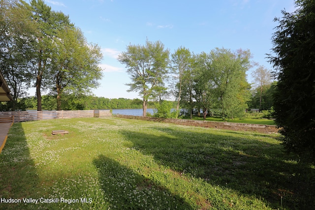 view of yard with a water view and fence