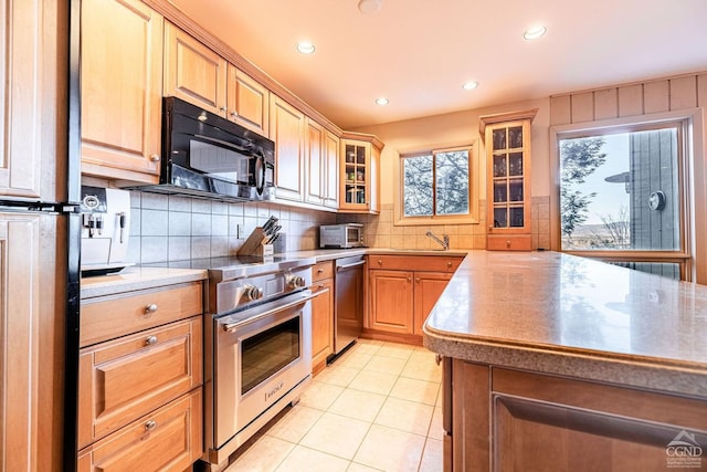 kitchen with stainless steel appliances, tasteful backsplash, glass insert cabinets, recessed lighting, and light countertops