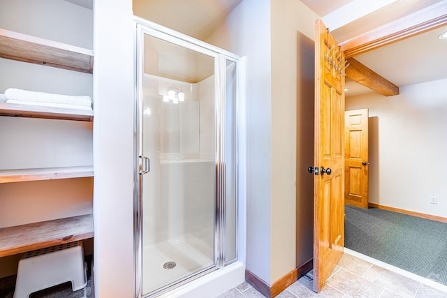 bathroom with a stall shower, beamed ceiling, baseboards, and tile patterned floors
