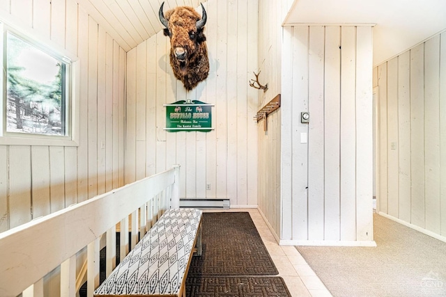 mudroom featuring wood walls, a baseboard heating unit, and lofted ceiling