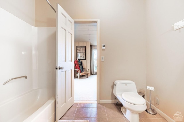 full bath with tile patterned flooring, toilet, baseboards, and washtub / shower combination