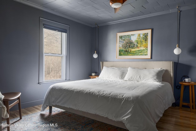 bedroom featuring ceiling fan, hardwood / wood-style floors, and ornamental molding