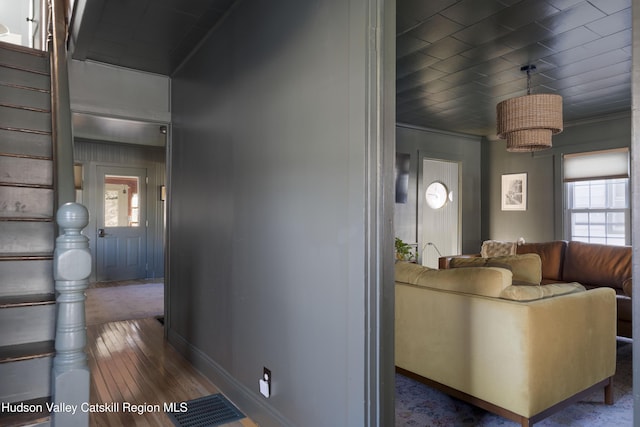 living room featuring a healthy amount of sunlight, crown molding, and dark wood-type flooring