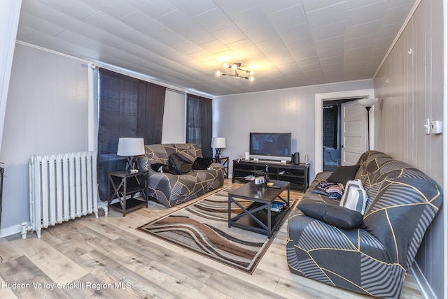 living area with radiator and wood finished floors