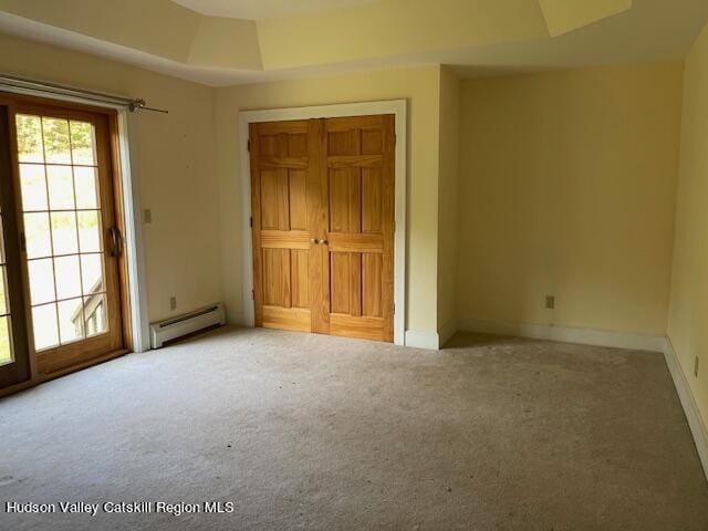 unfurnished bedroom featuring carpet flooring, access to outside, and a baseboard radiator