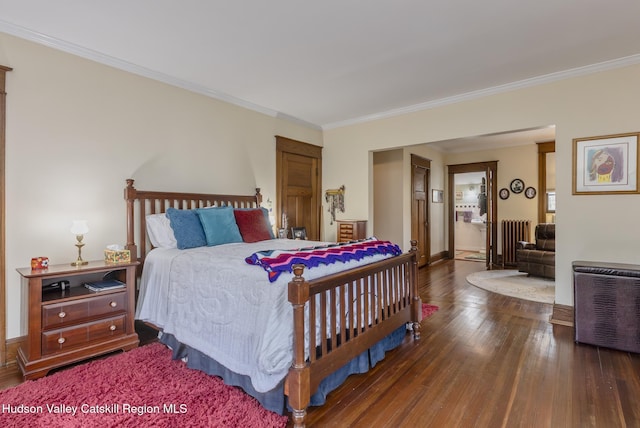 bedroom with radiator, baseboards, ornamental molding, and wood finished floors