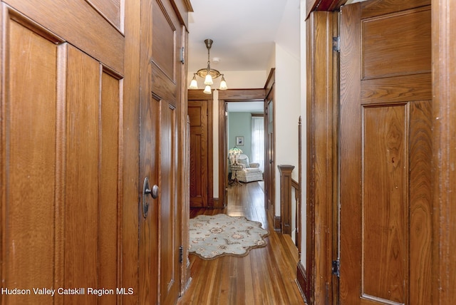 corridor featuring wood finished floors and an upstairs landing