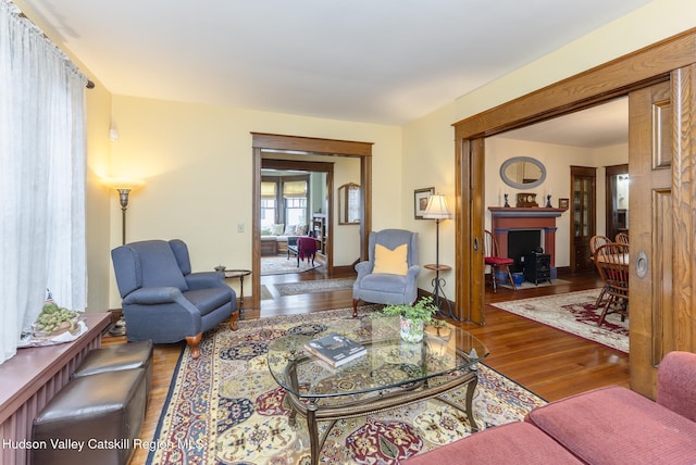 living room with a fireplace with flush hearth and wood finished floors