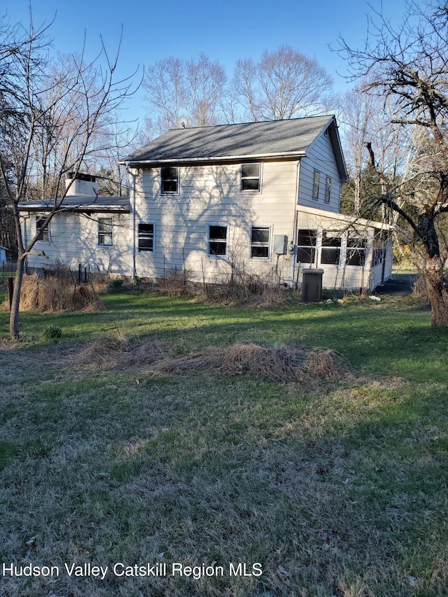 back of property featuring a lawn