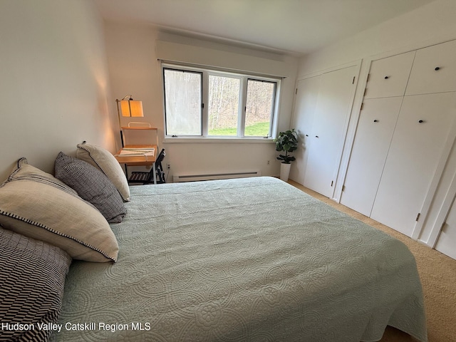 bedroom featuring carpet floors, multiple closets, and a baseboard radiator