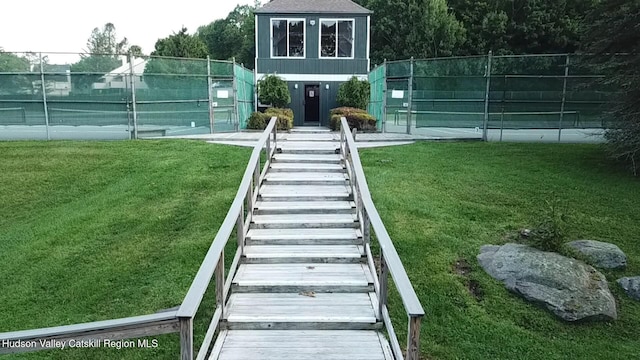view of yard featuring fence and a tennis court