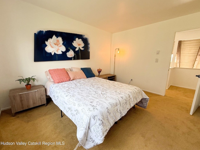 bedroom with baseboards and light carpet