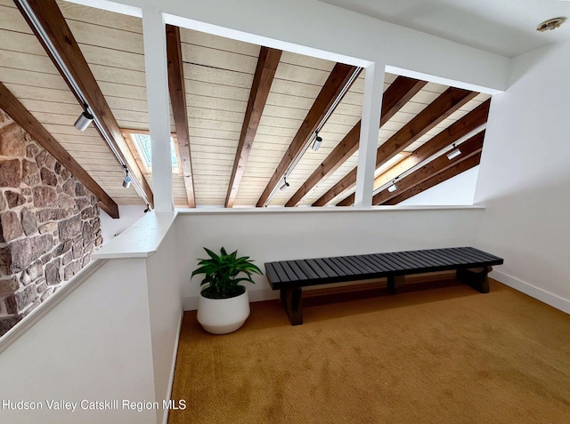 interior space with track lighting, carpet floors, beam ceiling, and wooden ceiling