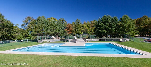 community pool featuring fence and a yard