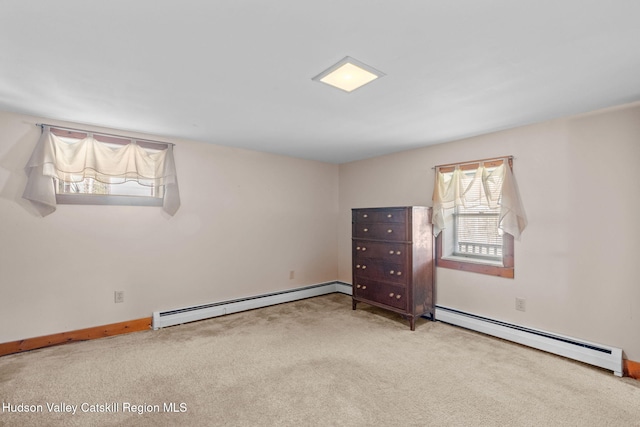 carpeted spare room with baseboard heating and baseboards