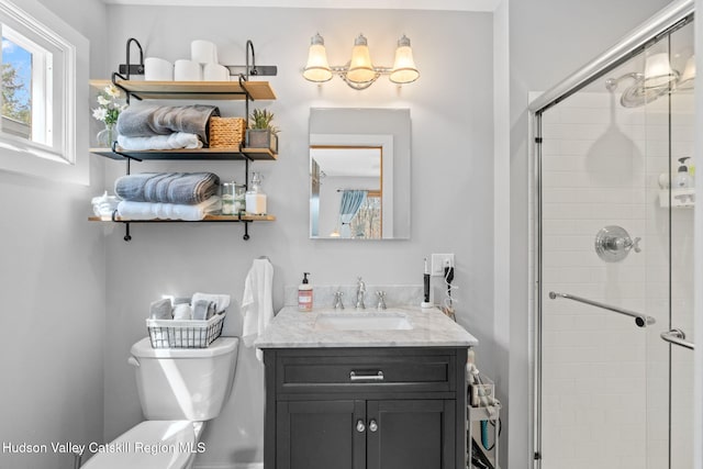 full bathroom featuring a stall shower, toilet, and vanity