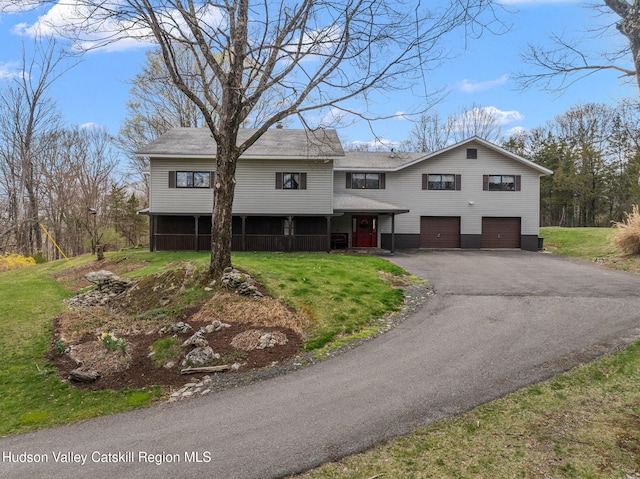 split foyer home with a front yard, driveway, and an attached garage