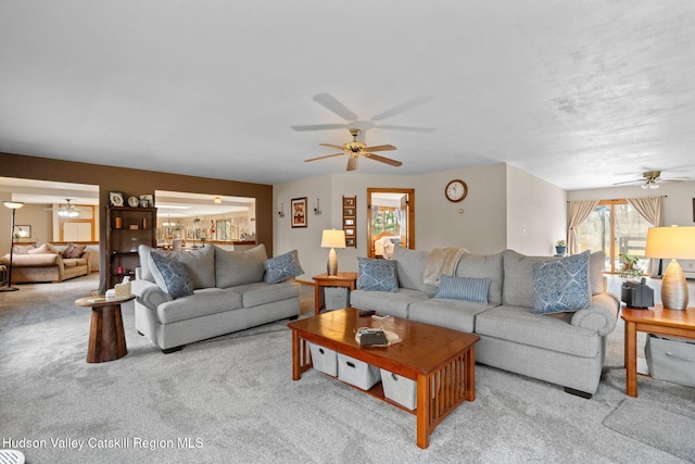 carpeted living area with a ceiling fan