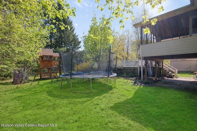 view of yard featuring a playground and a trampoline