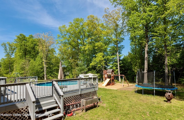 33 Camelot Ct, Saugerties, NY 12477 - outdoor pool with a trampoline, a playground, a lawn, a deck, and view of scattered trees