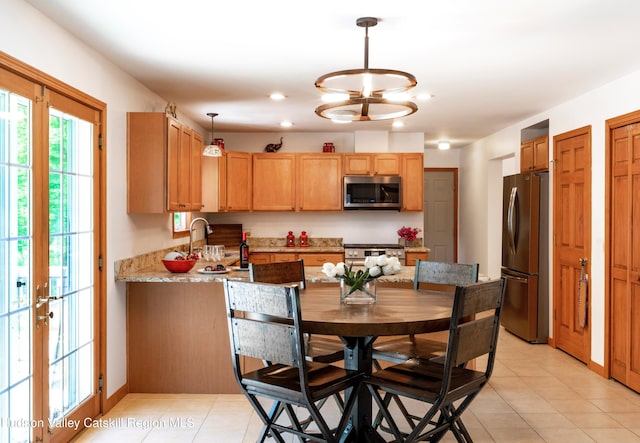 33 Camelot Ct, Saugerties, NY 12477 - kitchen featuring appliances with stainless steel finishes, a peninsula, pendant lighting, light tile patterned flooring, and light stone countertops