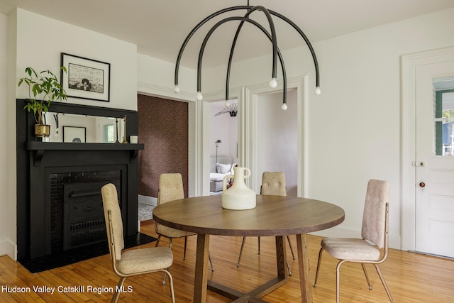 14 Bushnell Ave, Chatham, NY 12037 - dining space with light wood finished floors and a fireplace with flush hearth