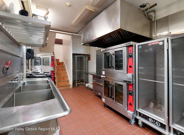 230 Warren St, Hudson, NY 12534 - kitchen featuring stainless steel counters, tile patterned flooring, a sink, and exhaust hood