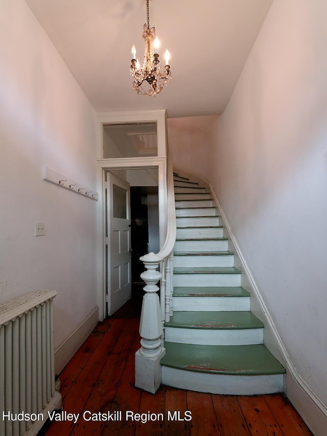 230 Warren St, Hudson, NY 12534 - staircase with radiator, hardwood / wood-style floors, a chandelier, and baseboards