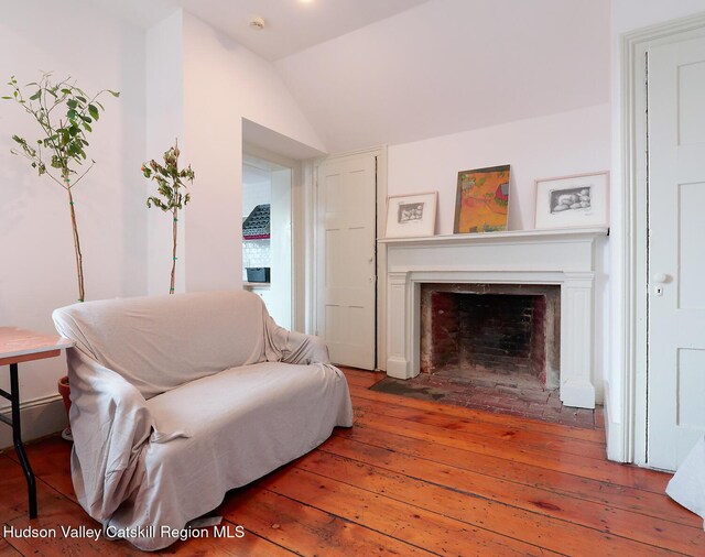 230 Warren St, Hudson, NY 12534 - sitting room with hardwood / wood-style floors, vaulted ceiling, and a fireplace with flush hearth