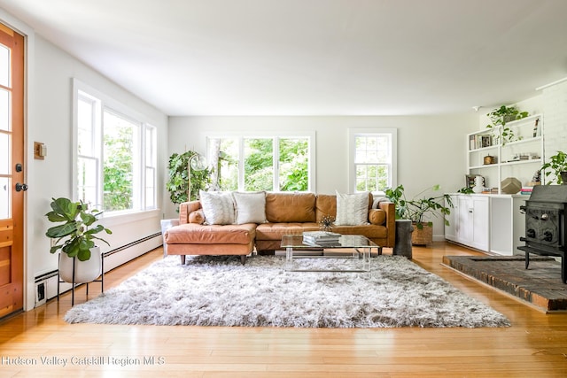 654 Watson Hollow Rd, West Shokan, NY 12494 - living room featuring a baseboard radiator, wood finished floors, and a wood stove