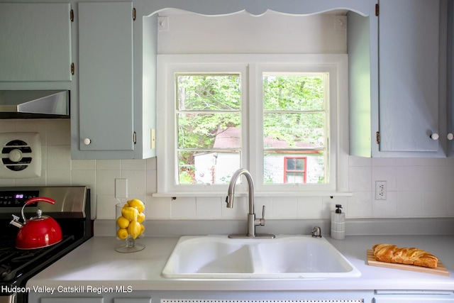 654 Watson Hollow Rd, West Shokan, NY 12494 - kitchen featuring wall chimney exhaust hood, stove, light countertops, and backsplash