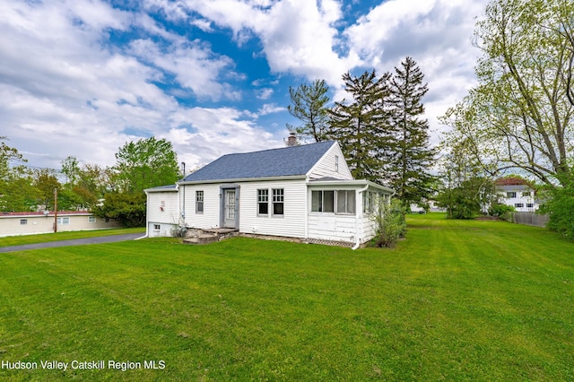 334 Joslen Blvd, Hudson, NY 12534 - view of front facade with a chimney, a front yard, and a sunroom