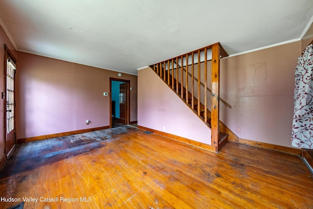 334 Joslen Blvd, Hudson, NY 12534 - unfurnished living room with baseboards, stairs, wood-type flooring, and ornamental molding
