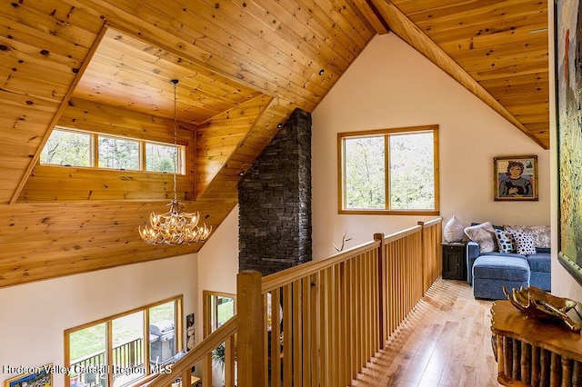 hallway featuring a chandelier, wood ceiling, light wood-style floors, an upstairs landing, and high vaulted ceiling