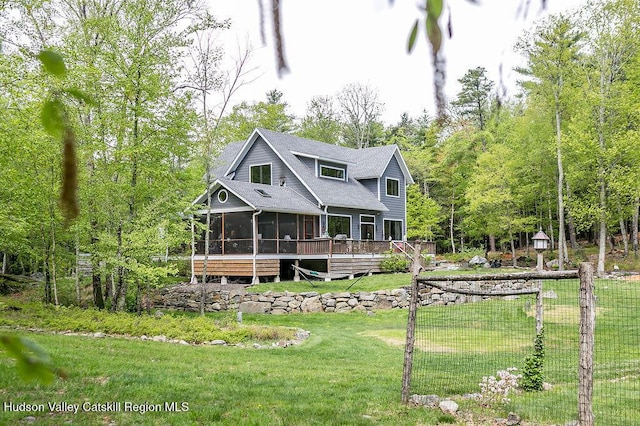 view of front of house with a sunroom, a front lawn, and a deck