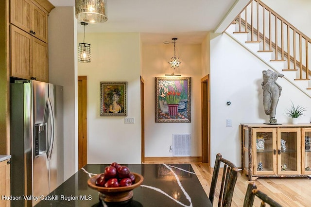 dining space with stairway and light wood-style flooring