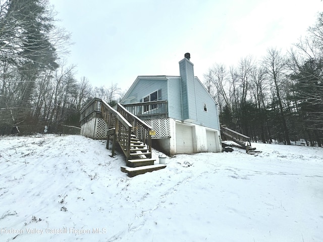 snow covered property featuring a garage