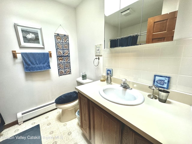 bathroom with tasteful backsplash, vanity, toilet, and a baseboard heating unit